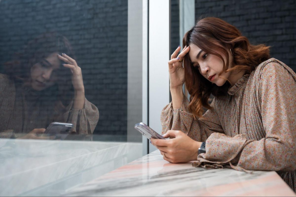 スマホ見て悩む女性